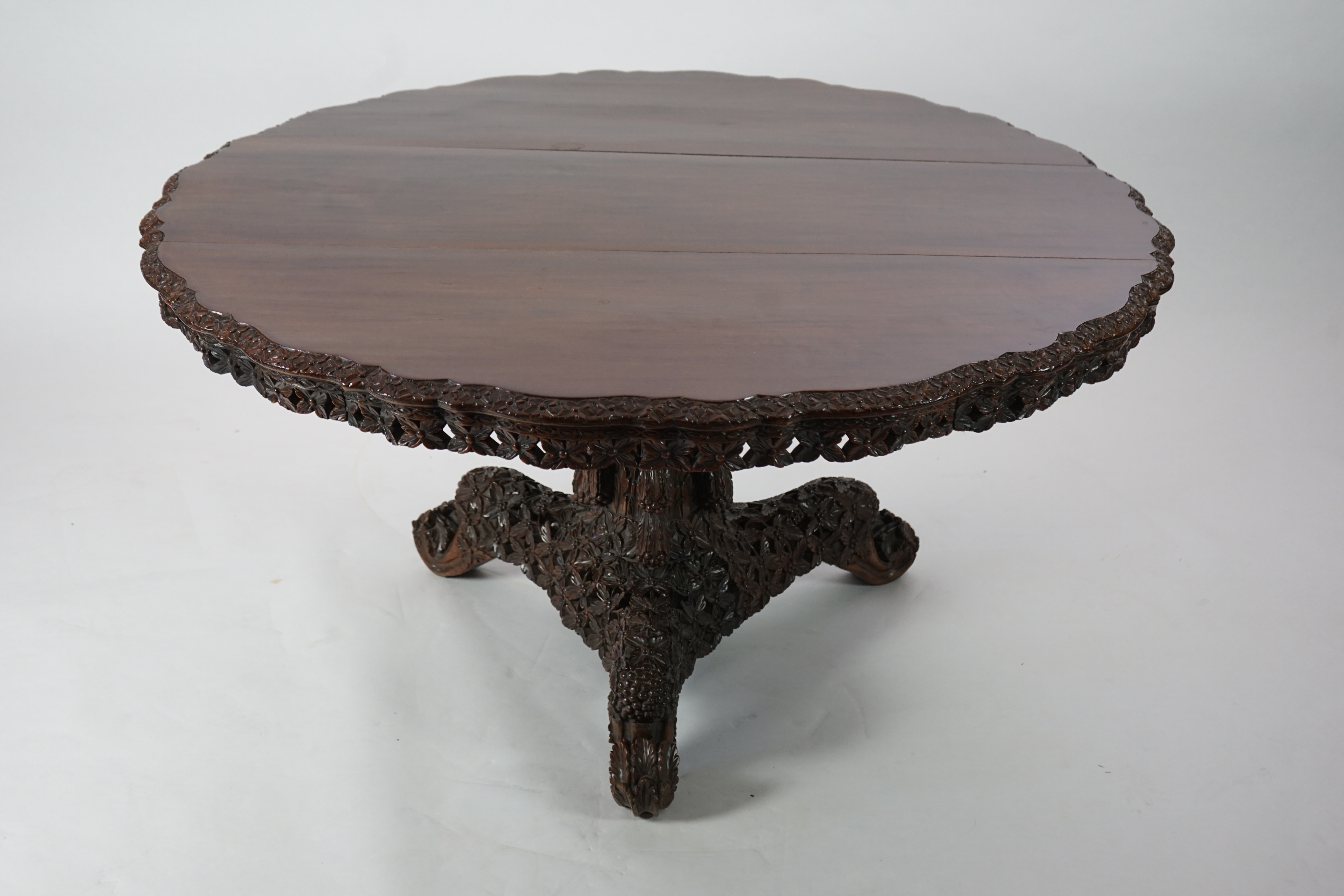 A 19th century Anglo-Indian hardwood foliate carved tilt top centre table